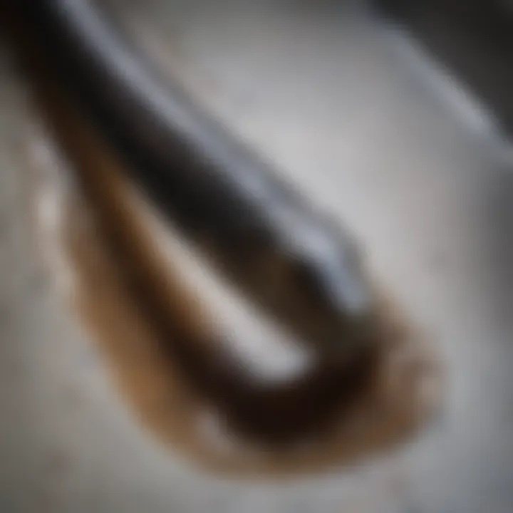Close-up of a drain being cleaned with a snake
