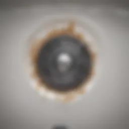 A close-up of a bathtub drain showing debris buildup
